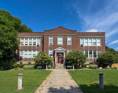 Warwick, NY - US - Jul 11, 2026 Doc Fry Building, the brick community center in Warwick, NY with symmetrical facade, central entrance, large windows, and landscaped grounds under vivid blue summer sky