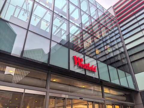 Modern glass exterior and distinctive red logo of Westfield Stratford City shopping mall in London