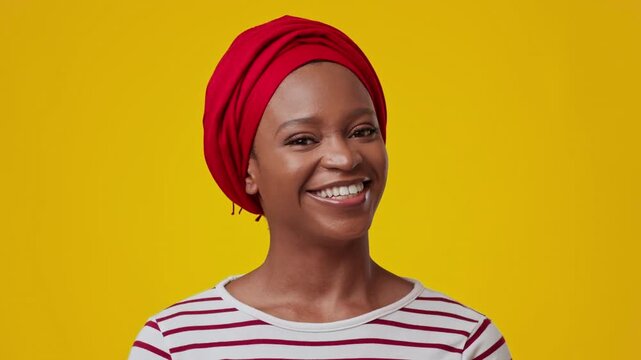 Smiling Black Woman In Red Headwrap And Striped Shirt, Radiating Happy Emotion While Posing For Portrait In Bright Studio With Yellow Background, Celebrating Confidence And Beauty Concept.