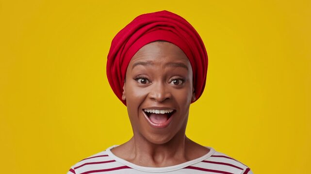 Joyful Emotion. Happy Black Woman In Her 30s With Red Headwrap Smiling Brightly, Standing Against A Yellow Background, Expressing Happiness And Positive Vibes, Concept Of Joy And Celebration.