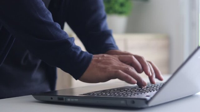 Man hand typing on laptop keyboard. Male programmer, freelancer, businessman or office worker working on computer, writing message, an engineer using laptop coding to develop software in room at home.