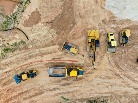 Aerial Top Down View of Heavy Construction Machinery Fleet on Dirt Site