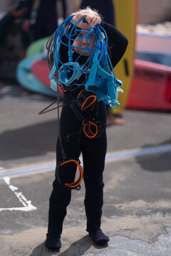 Funny child holding a bunch of tangled surf leashes. 