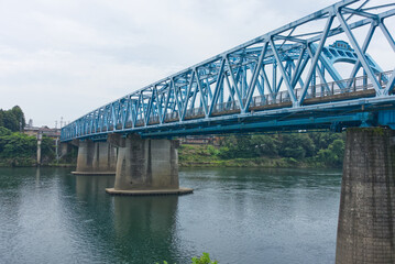 Fototapeta premium 木曽川に架かる青いトラス橋、美濃加茂市の太田橋の風景
