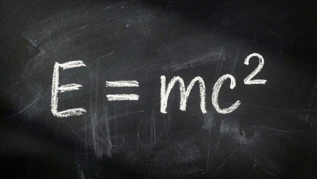 Blackboard equation mc2 written white chalk simple sans-serif font centered background black chipped faded giv