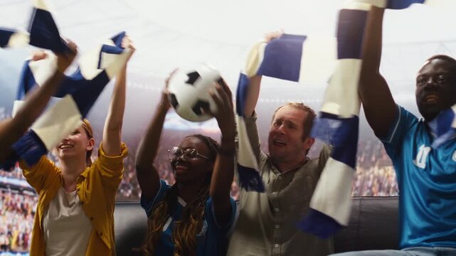 Football fans on couch at home with beer cups and team scarves watch match broadcast as friends enjoy interactive viewing with realistic stadium feeling.