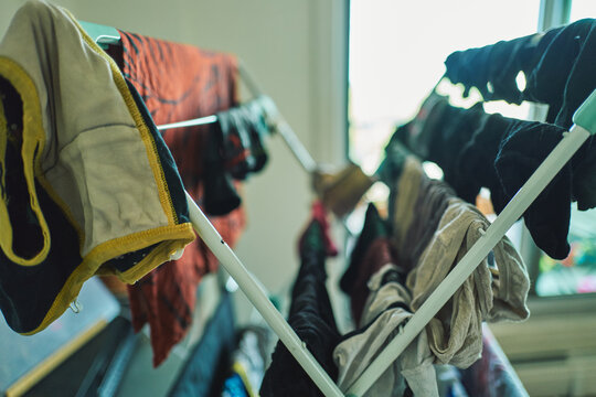 Clothes drying on a folding rack indoors by a window