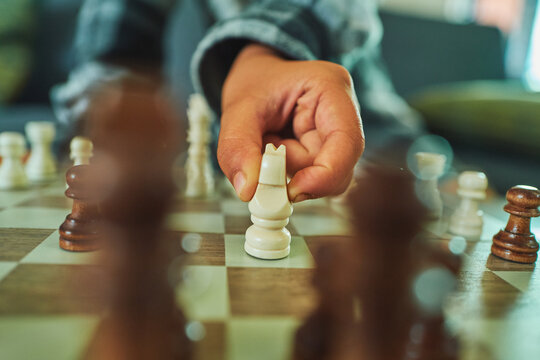 Hand moving a knight on a chess board - close-up