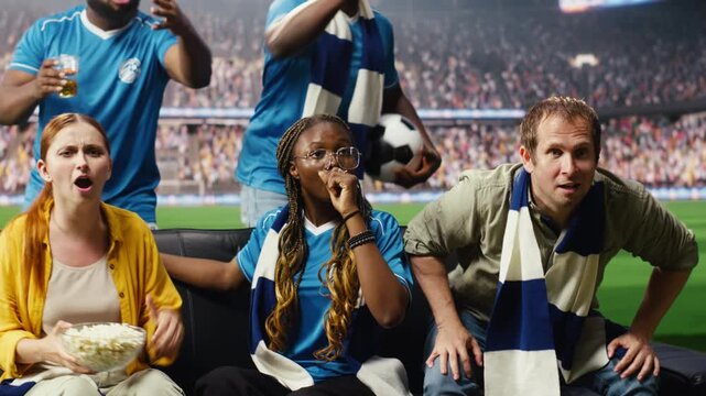 Jolly soccer fans on couch cheer after goal, feeling like they are inside the stadium as ecstatic football supporters at home enjoy immersive match day during TV broadcast and stadium feeling.