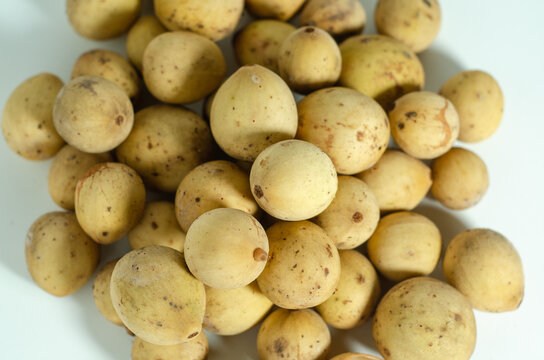 Fresh ripe duku fruits arranged on a white background. Sweet tropical fruit from Indonesia, ideal for healthy food, agriculture, and exotic fruit concepts.