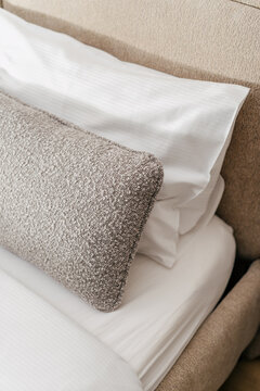 Cushions and pillows arranged on bed in hotel room for a comfortable stay