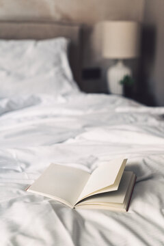 Morning journal open on bed in modern bedroom for weekend reading activity