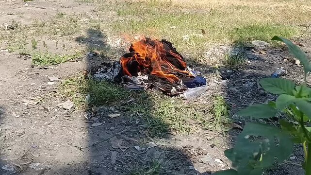 Pembakaran sampah di kebun siang hari 