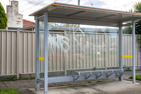 A bus stop shelter showing signs of property damage and vandalism in Melbourne, Australia. Issue of spray-painted graffiti tags on public asset, antisocial behavior