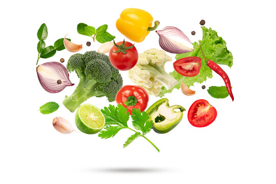 Mix of falling fresh vegetables including broccoli, tomato, bell peppers, onion, lime, and herbs. Healthy organic food ingredients isolated on white background.