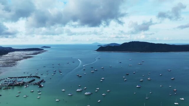 Aerial view Drone hyperlapse of Yacht and sailboat in the pier, Chalong bay Phuket thailand,Amazing sunny sky clouds over sea,Timelapse sky sunny day time, Blue sky clouds background