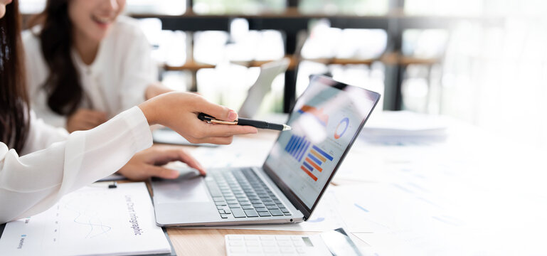 Close-up of Businesswoman Pointing at Financial Chart on Laptop Screen