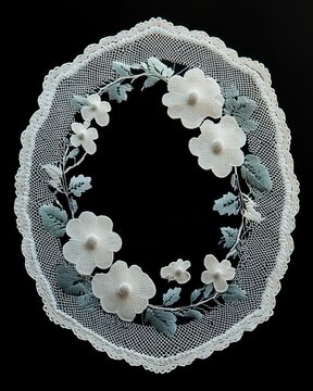 Delicate oval lace doily with embroidered white flowers and green leaves on black background, elegant vintage charm