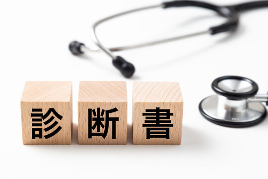 「診断書」と書かれたブロックと聴診器