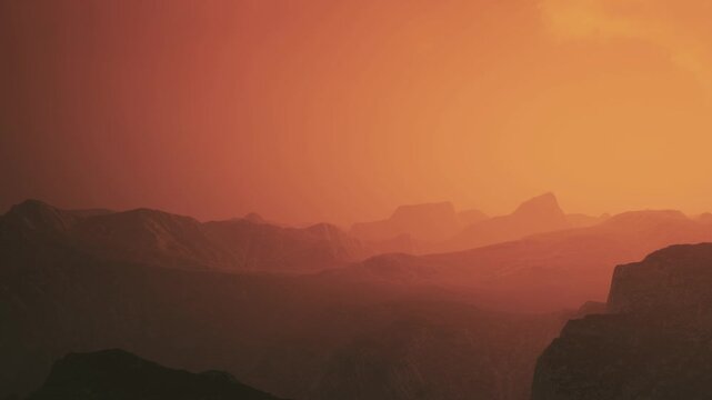 A large mountain range covered in shadows is visible as the sun sets. Colors transition from bright to dark while the landscape shows distant peaks and valleys.