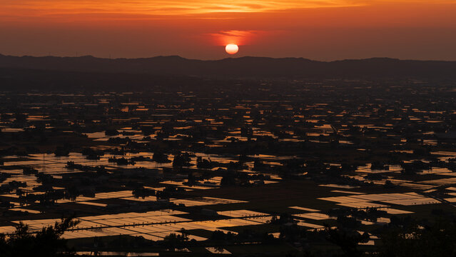 High-angle sunset view of the iconic Sankyoson dispersed settlement and flooded rice paddies in Toyama, Japan
