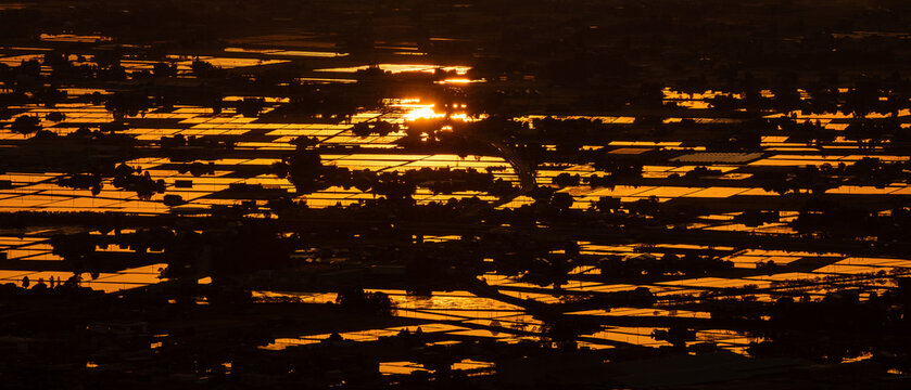High-angle sunset view of the iconic Sankyoson dispersed settlement and flooded rice paddies in Toyama, Japan