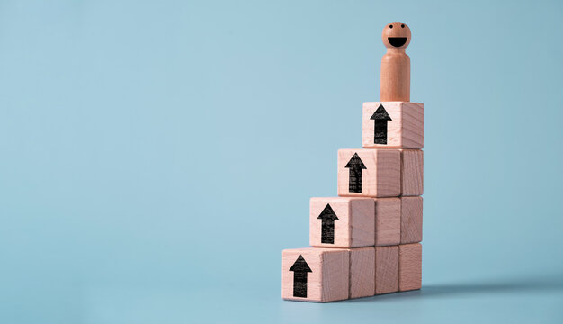 Wooden figure standing on rising blocks with upward arrows represents career growth, business success, personal development, leadership, goal achievement, promotion and continuous improvement.