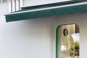 Naklejka premium Arched doorway with green frame and hanging clock