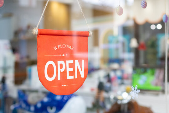 Vibrant orange "Open" flag hangs on storefront window