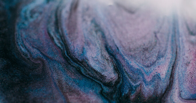 Shimmering fluid blur. Paint stream. Purple blue liquid pigment wave spill with black gray glitter mixing color abstract background.