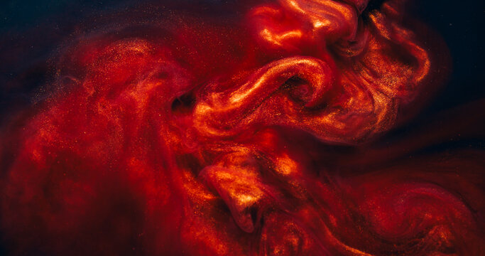 Sparkling ink blend. Dust fluid. Shimmering metallic particles paint copper red smoke flow. Mysterious color mix splash blur abstract black background.