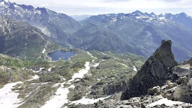 High-alpine panorama with a mountain lake switchback road and Bernese