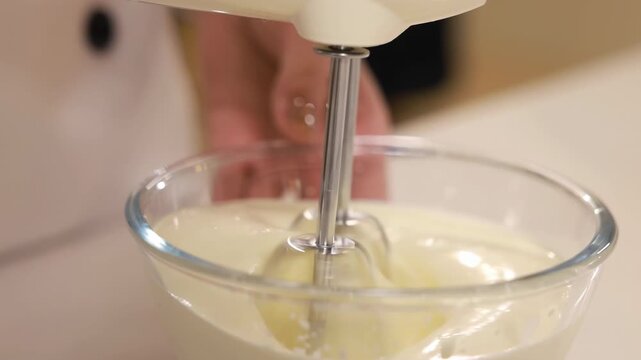 Pastry chef hand cooking adds sugar flour in white bowl whipping raw egg whites with butter with electric mixer beats with whisk for delicious birthday bakery order, baking, confectionery, culinary