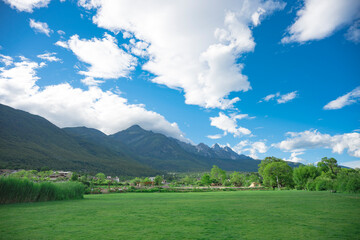 jade dragon snow mountain with grass and blue sky © Chad Photo