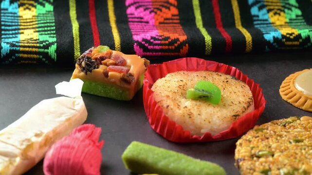Variety of traditional Mexican sweets on a dark background with artisanal textile
