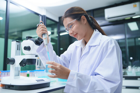 Laboratory Technician Conducting Chemical Tests with Pipette and Microscope