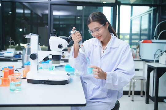 Scientist Using Pipette for Chemical Experiment in Laboratory