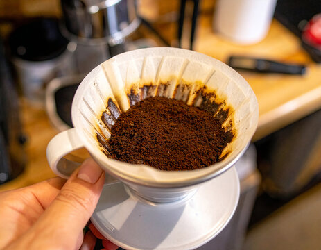 Barista Hand Holding Fresh Ground Coffee in Paper Filter for Brewing