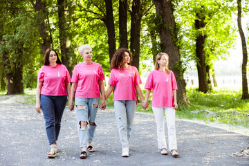 Obraz premium Diverse group of women wearing pink t shirt with pink ribbon walking together in park