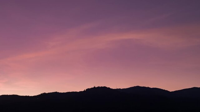 Evening sky time-lapse capturing the shift from sunset glow to night time darkness with subtle cloud movement.