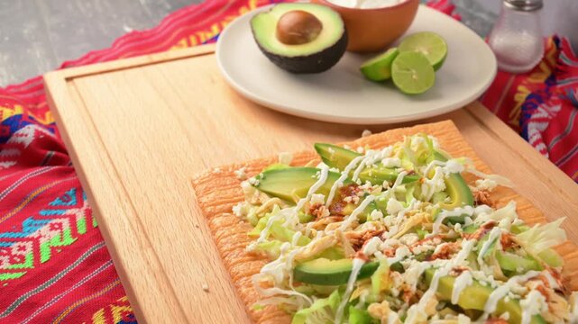 Aerial view of Mexican street food snack chicharron preparado on wooden board with ingredients background