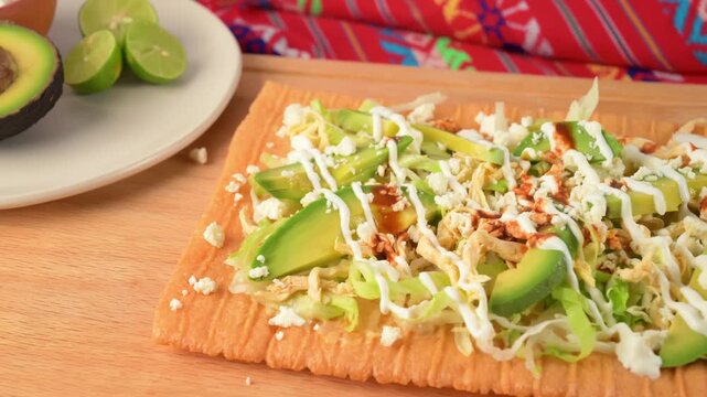 Aerial view of traditional Mexican chicharron preparado with lettuce, avocado, sour cream and hot sauce