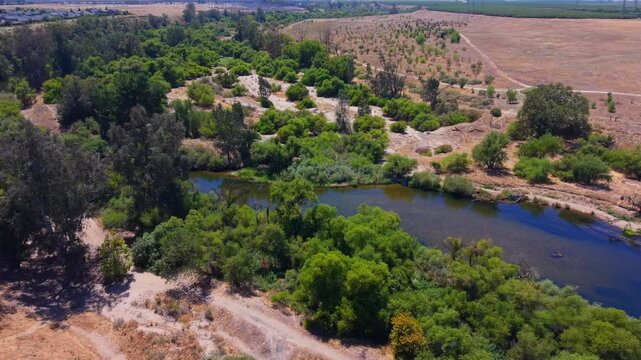 Still Aerial Drone Shot Over San Joaquin River With Trees Bushes and Hiking Trails in Fresno California