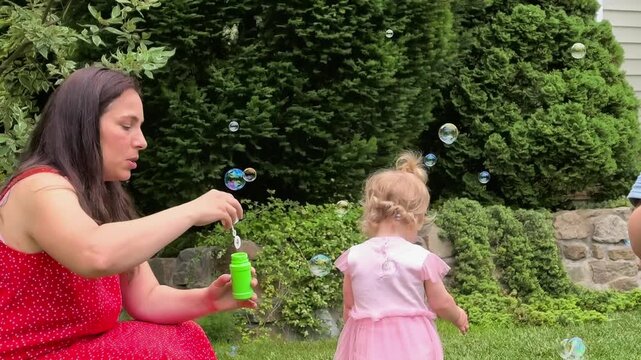 Children Watching Soap Bubbles Blown By Their Mother