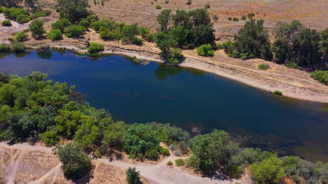 Panning Aerial Drone Shot Right to Left Over San Joaquin River With People Swimming and Trees in Fresno California