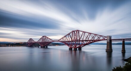 Naklejka premium Red cantilever bridge over calm water at twilight.