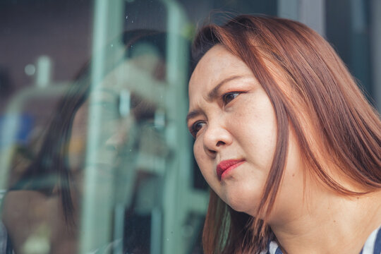 Sad and depressed Asian middle-aged woman facing emotional stress and anxiety inside a lifestyle environment. Concept of severe mental health crisis, burnout syndrome, depression, business failure, de