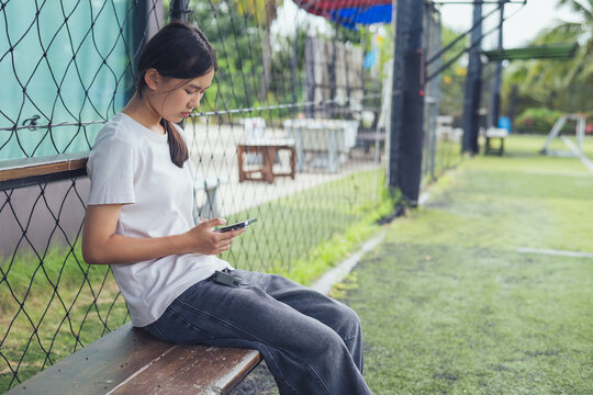 Worried and stressed Asian teenager girl holding smartphone looking at screen with anxious expression. Concept of cyberbullying, social media peer pressure, smartphone digital addiction, and youth men