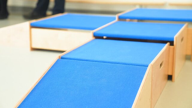 Modern, wooden modular furniture with blue cushions in a kindergarten or elementary school