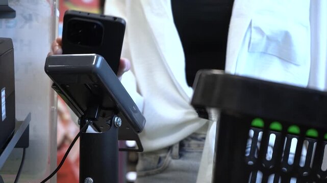 Self-Checkout System in Action: A Close-Up View of a Customer Using a Mobile Device for Payment at a Retail Checkout Counter